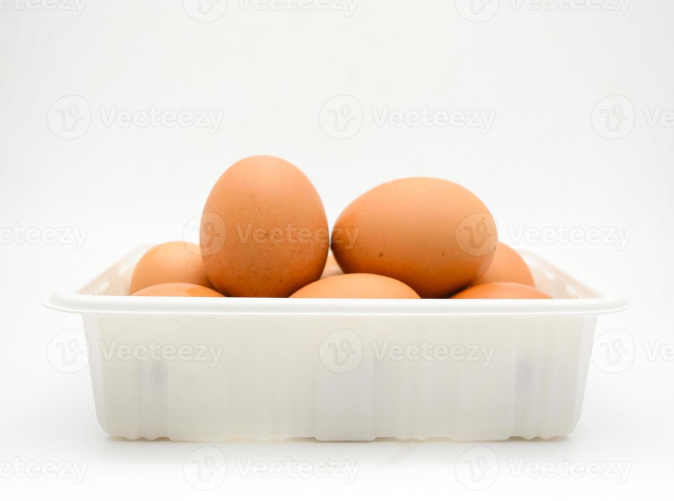 ovos, ovos marrons frescos na caixa de plástico branca foto