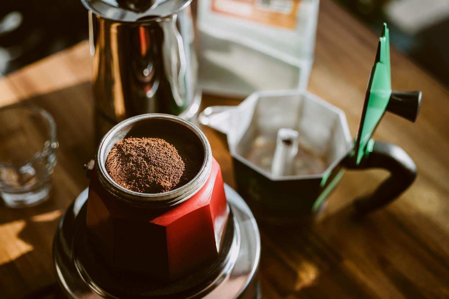 café moído finamente e cafeteira vintage moka pote na mesa de madeira em casa, foco seletivo. foto