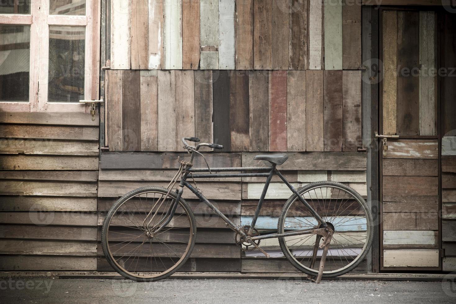 pé de bicicleta vintage perto de uma parede de madeira vintage foto