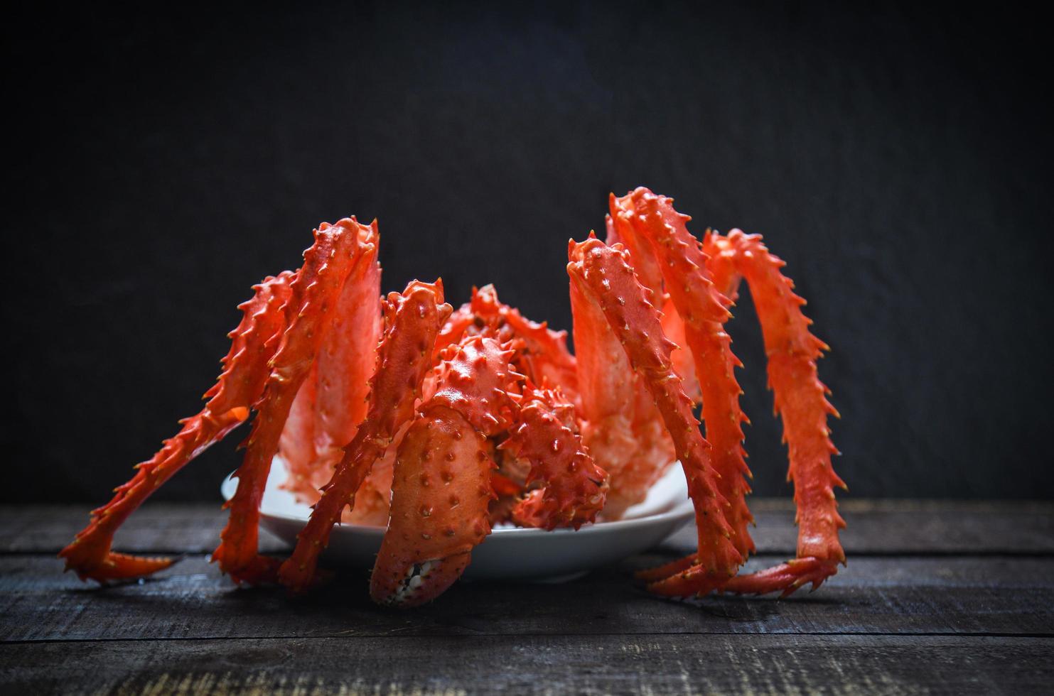 caranguejo-rei cozinhado comida a vapor em pratos de frutos do mar com fundo escuro - caranguejo vermelho do alasca hokkaido foto