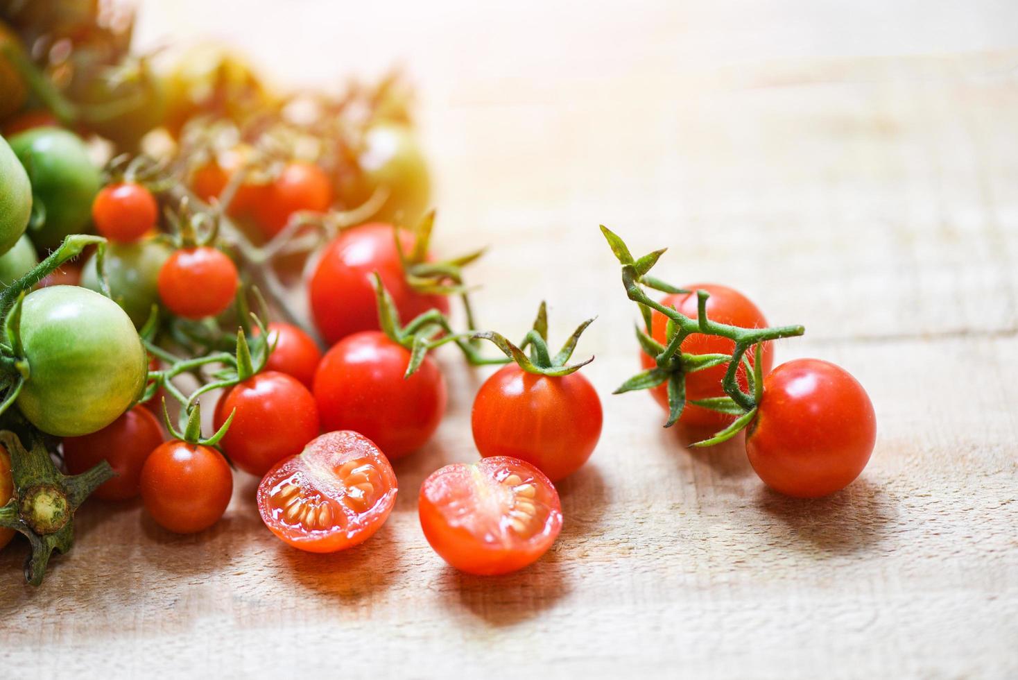 colheita de tomate fresco orgânico com tomates vermelhos verdes e maduros em madeira foto