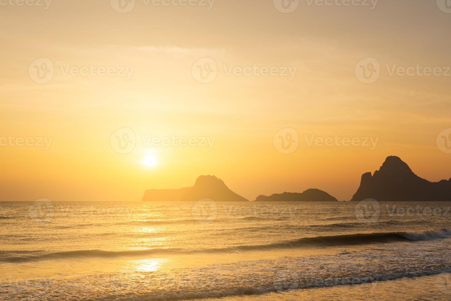 Seascape nascer do sol com montanhas e ondas suaves pela manhã. foto