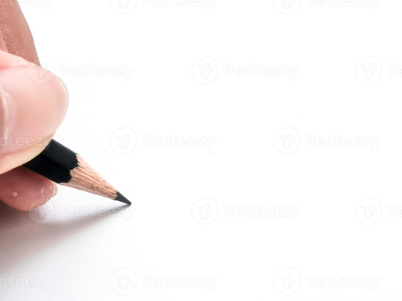 mão segurando um lápis preto pronto para escrever algo no papel foto