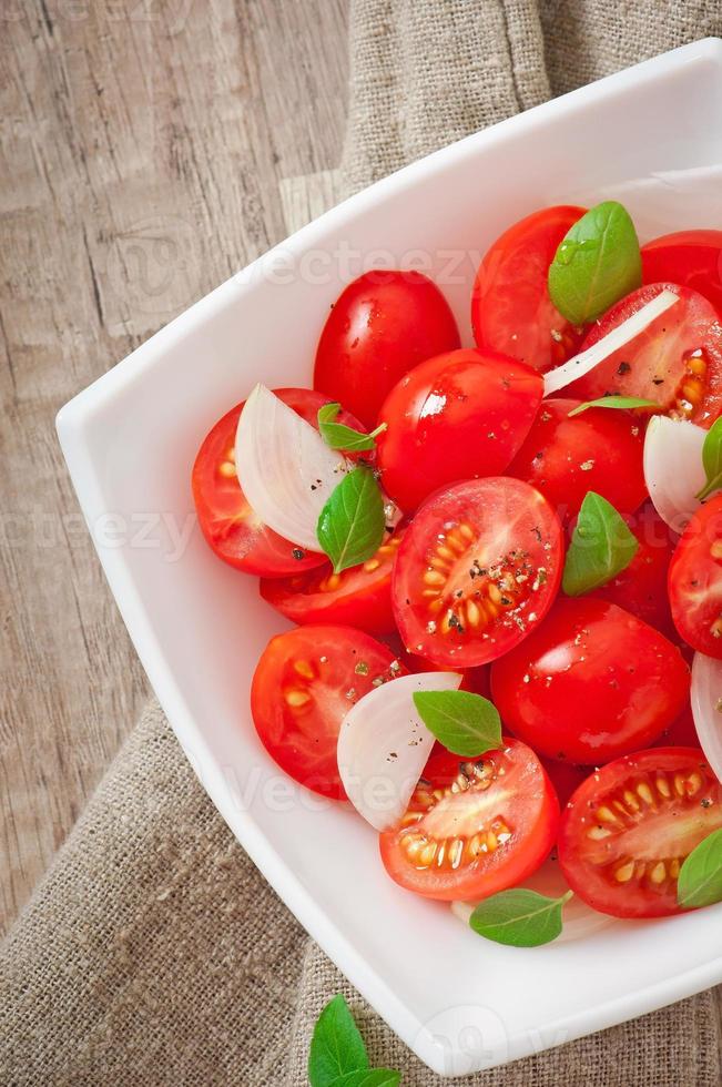 salada de tomate cereja com manjericão, pimenta preta e cebola foto