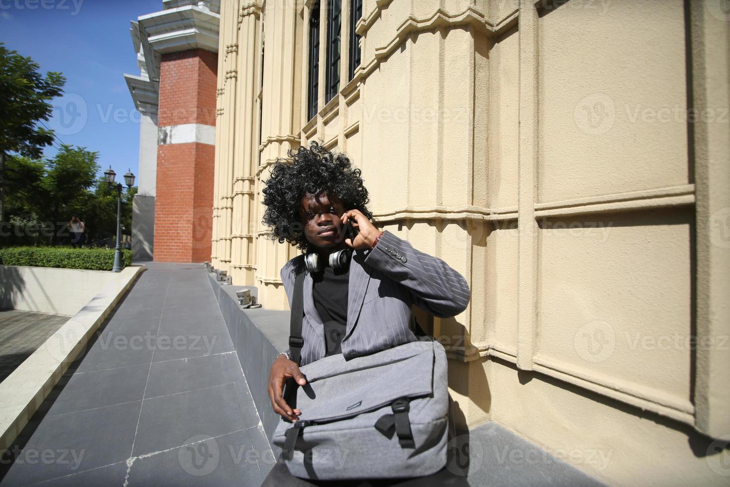 homem afro-americano se divertindo andando no centro da cidade - cara jovem feliz aproveitando o tempo um pôr do sol ao ar livre - estilo de vida da geração milenar e conceito de atitude positiva das pessoas foto