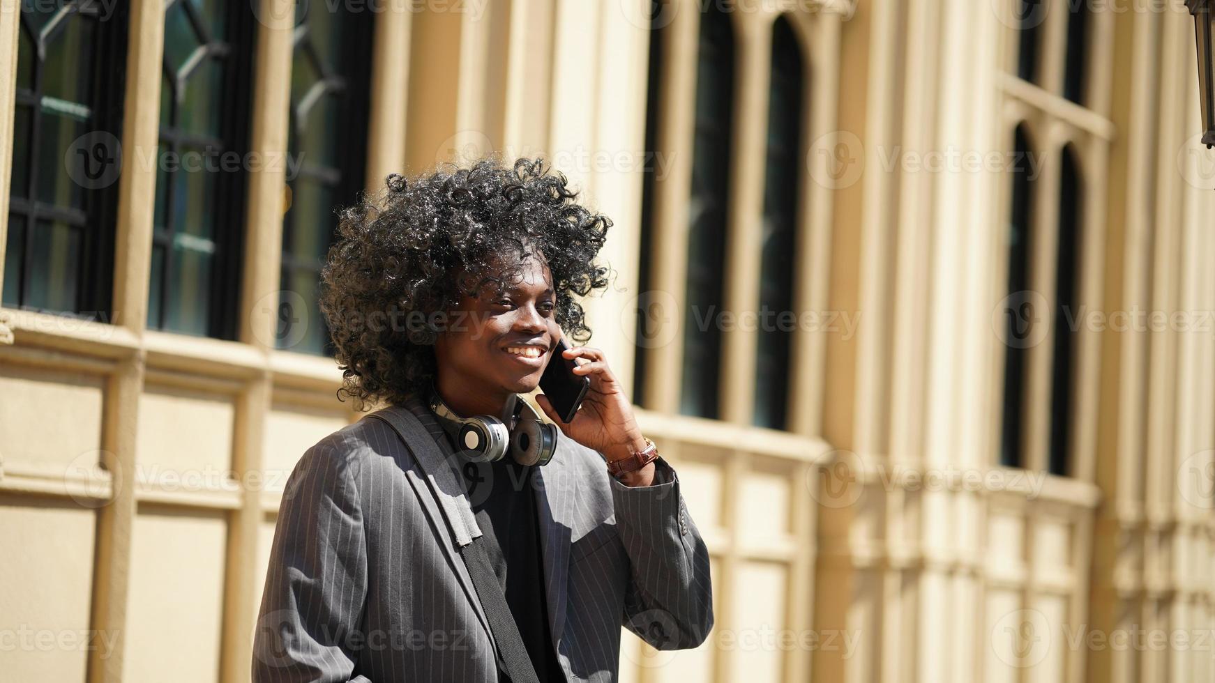 homem afro-americano se divertindo andando no centro da cidade - cara jovem feliz aproveitando o tempo um pôr do sol ao ar livre - estilo de vida da geração milenar e conceito de atitude positiva das pessoas foto