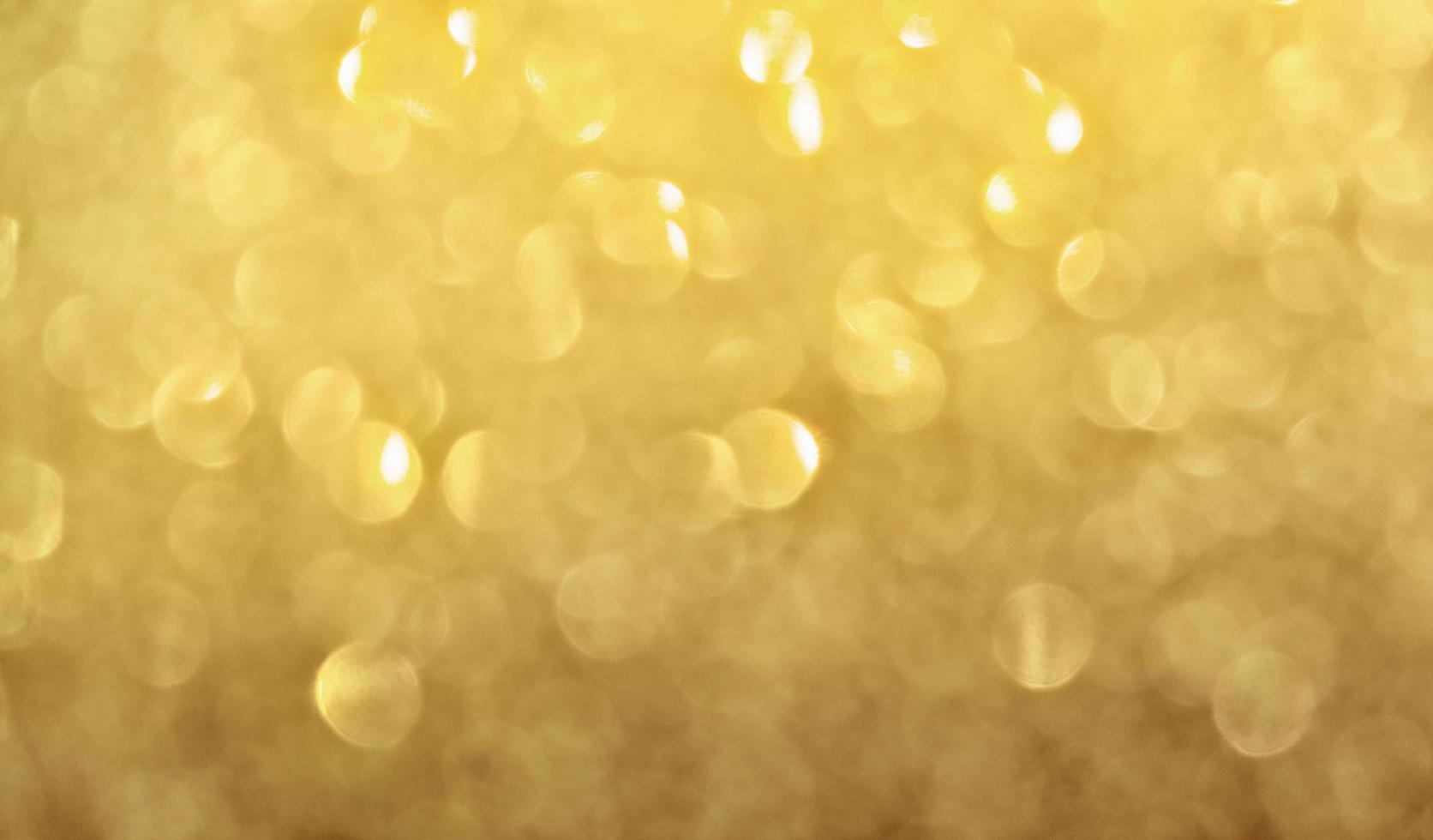 fundo de bokeh de luz de Natal de brilho de ouro abstrato. foto