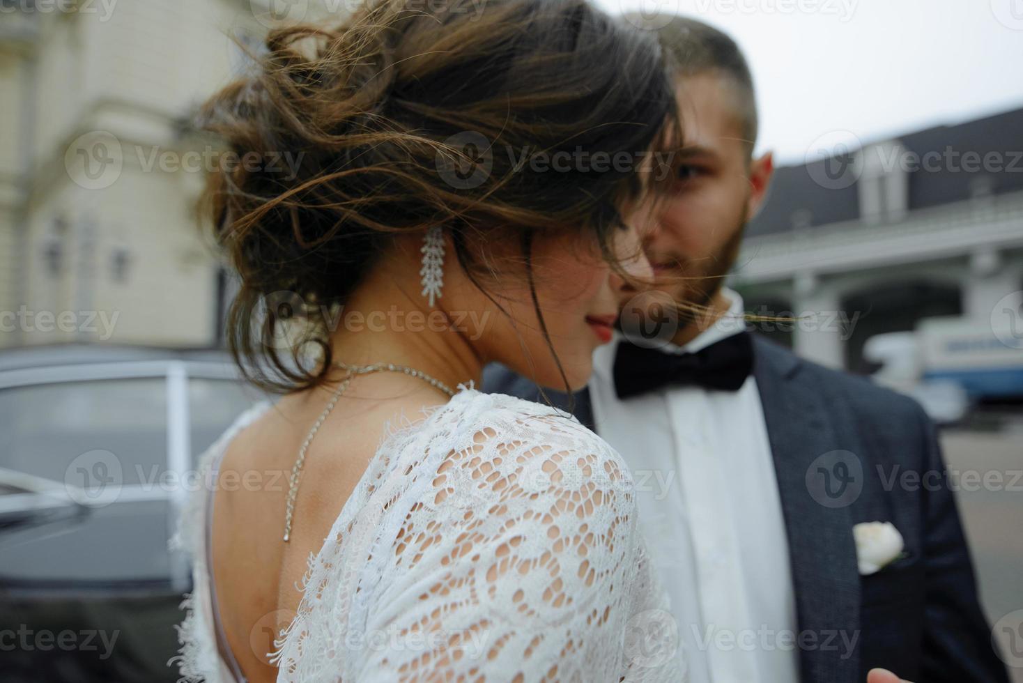 linda noiva linda e elegante noivo bonito, casal rústico em um campo de girassol se beijando foto