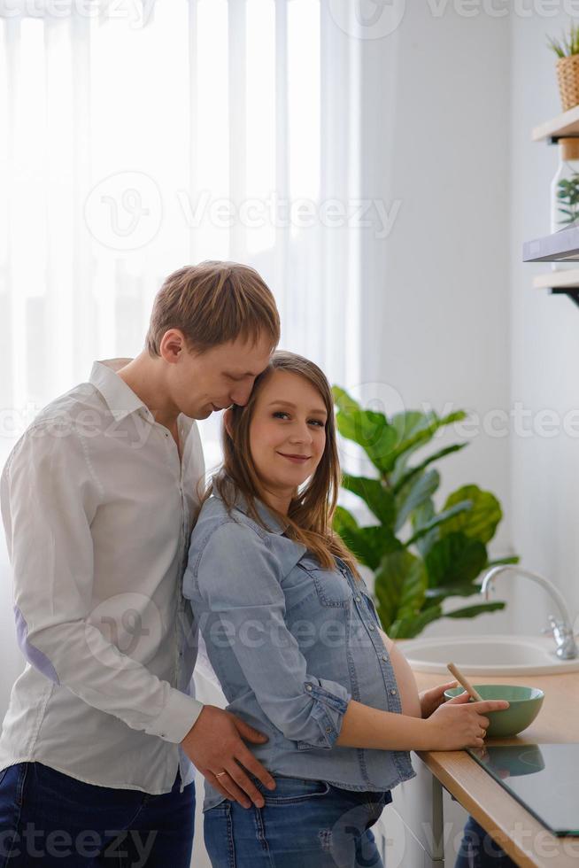 homem abraçando sua esposa grávida foto