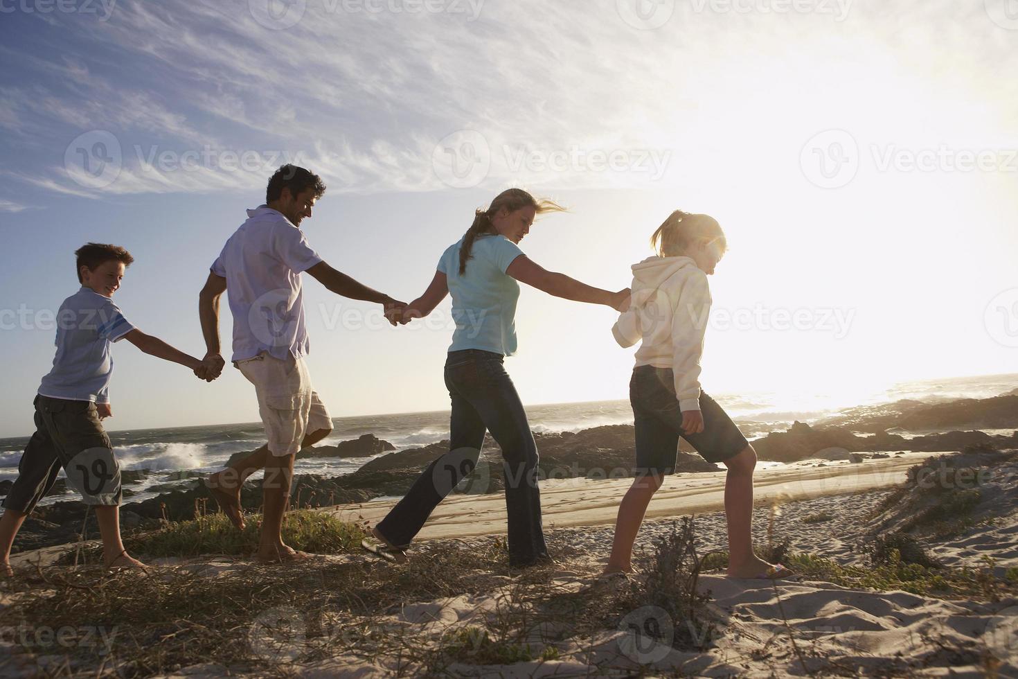 família caminhando na praia foto