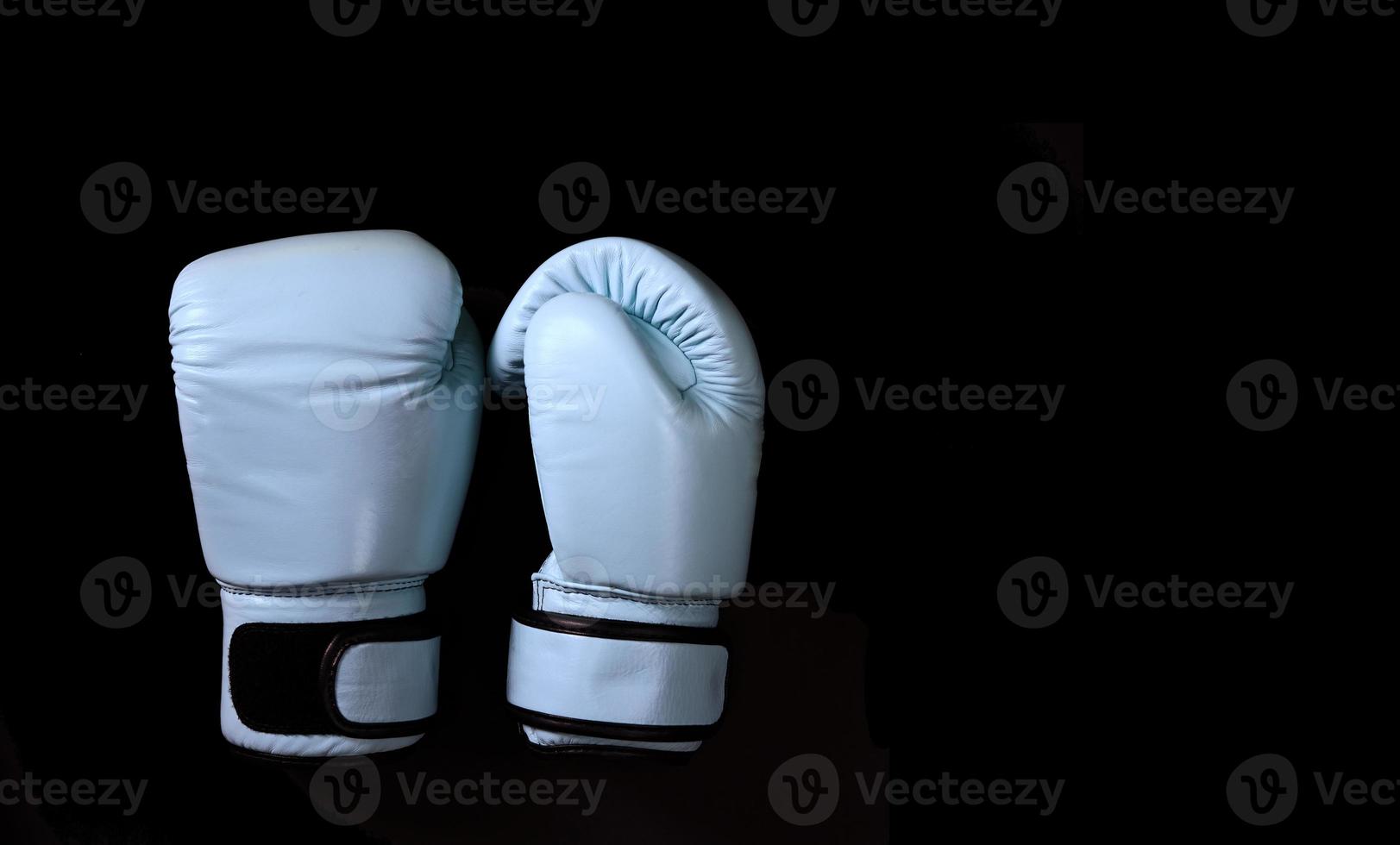 luvas adesivas de boxe em fundo preto foto