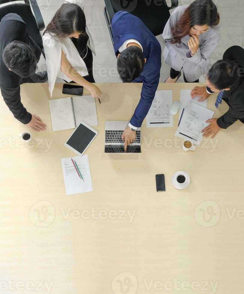 conceito de banner de trabalho de negócios verticais. equipe corporativa asiática reunida e usar o laptop na mesa na sala de reuniões, copie o espaço. foco seletivo. foto