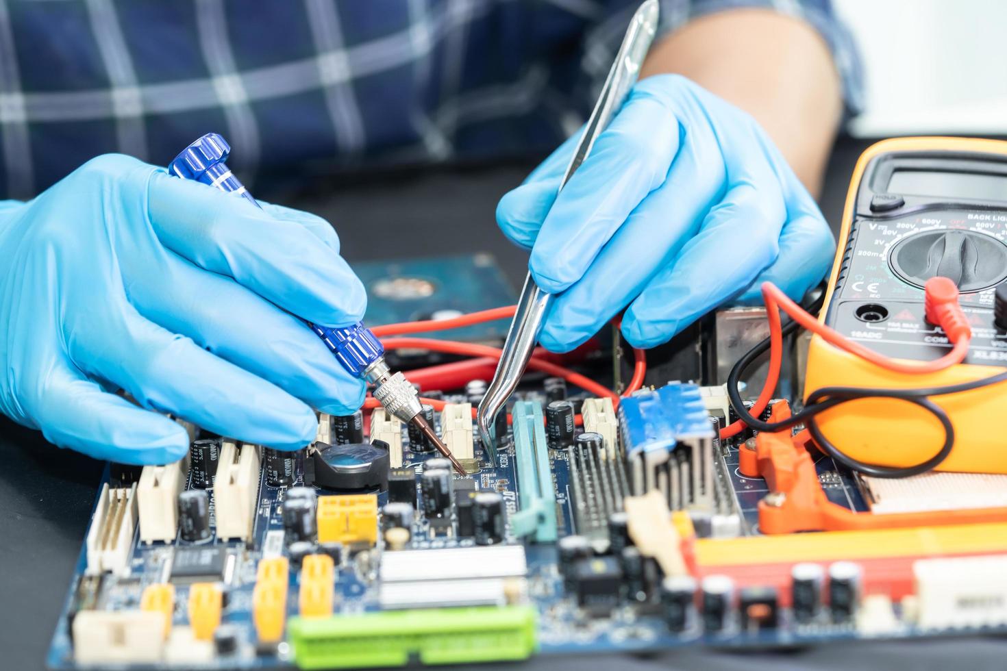 técnico que repara dentro do telefone móvel com ferro de solda circuito integrado. o conceito de dados, hardware, tecnologia. foto