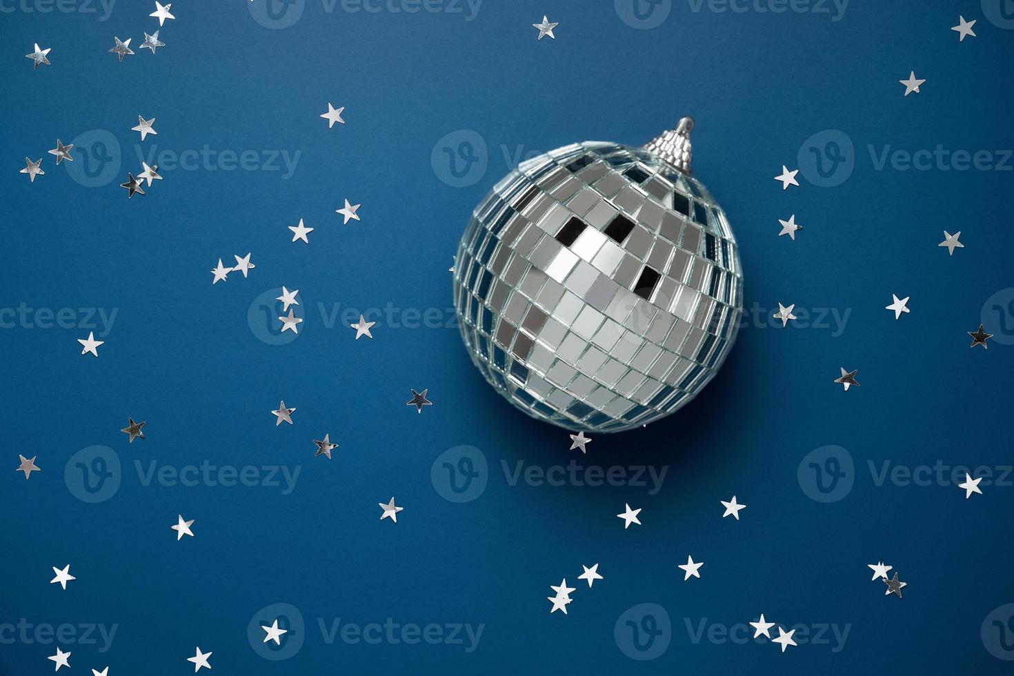 bola de discoteca em fundo azul com estrelas prateadas foto