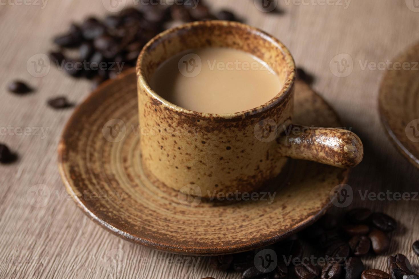 café quente em xícara marrom com fundo de madeira foto