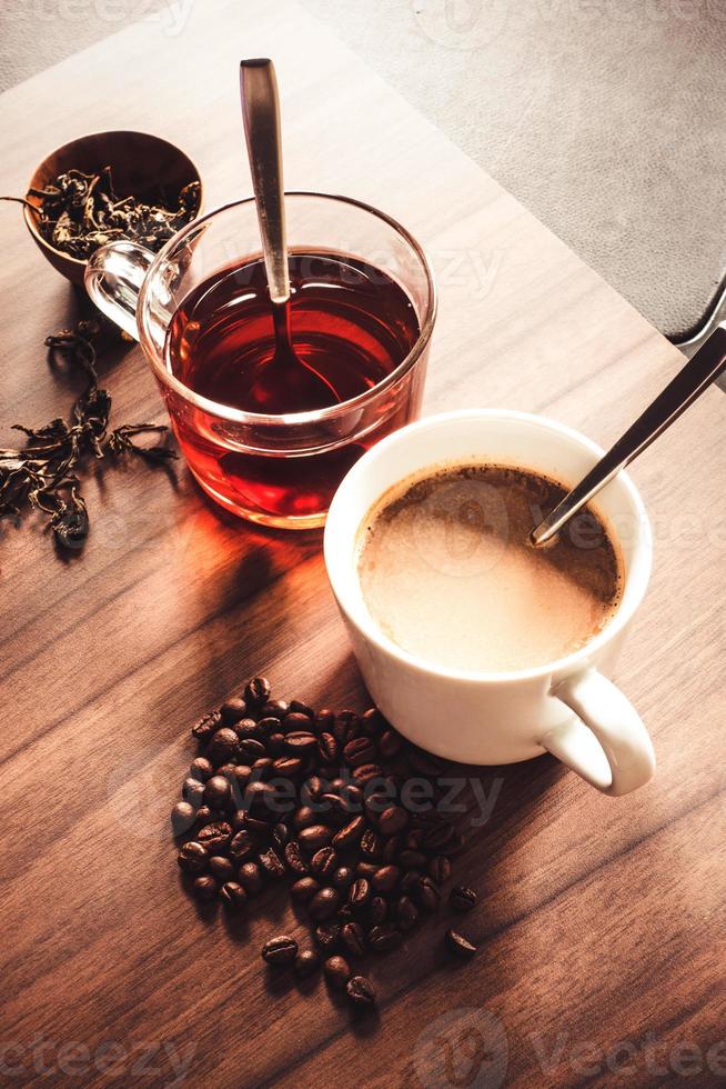 café e chá com grãos de café e folhas de chá no piso de madeira. foto