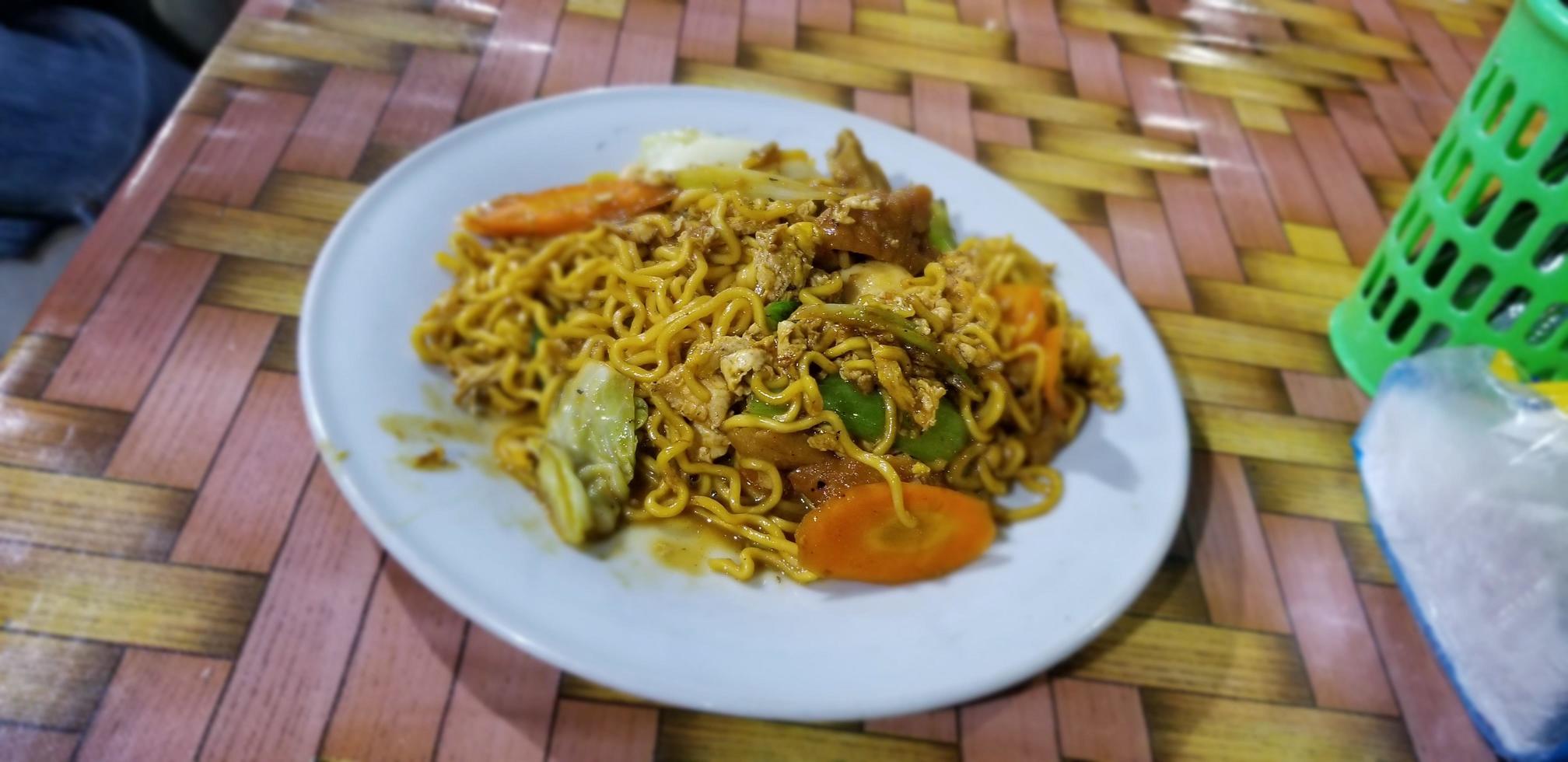 um prato de macarrão frito com legumes foto