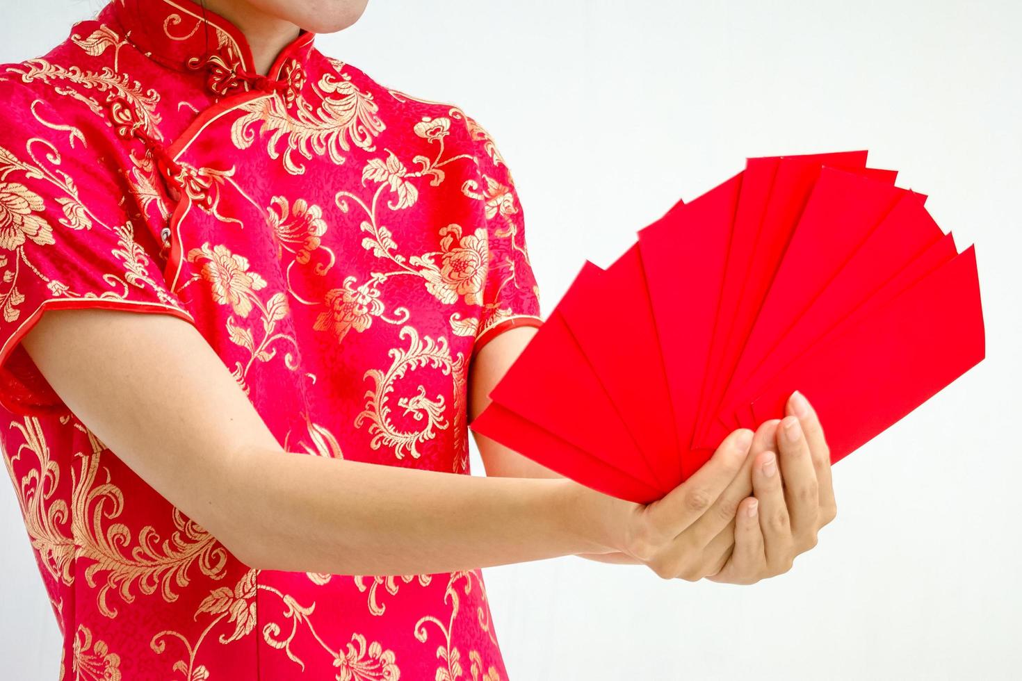 mulher asiática segurando envelope vermelho, mulher veste cheongsam, ano novo chinês foto