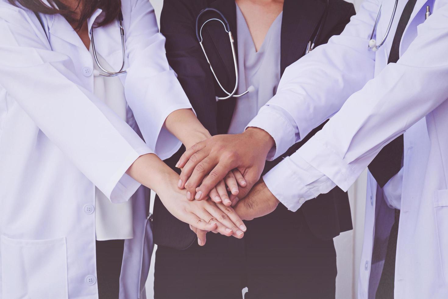 médicos e enfermeiros coordenam as mãos. trabalho em equipe conceito foto