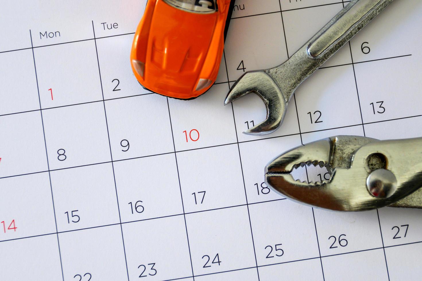 chave inglesa e carro no calendário com números. conceito de reparo foto