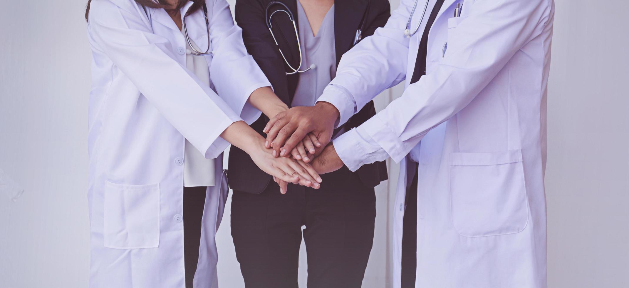 médicos e enfermeiros coordenam as mãos. trabalho em equipe conceito foto