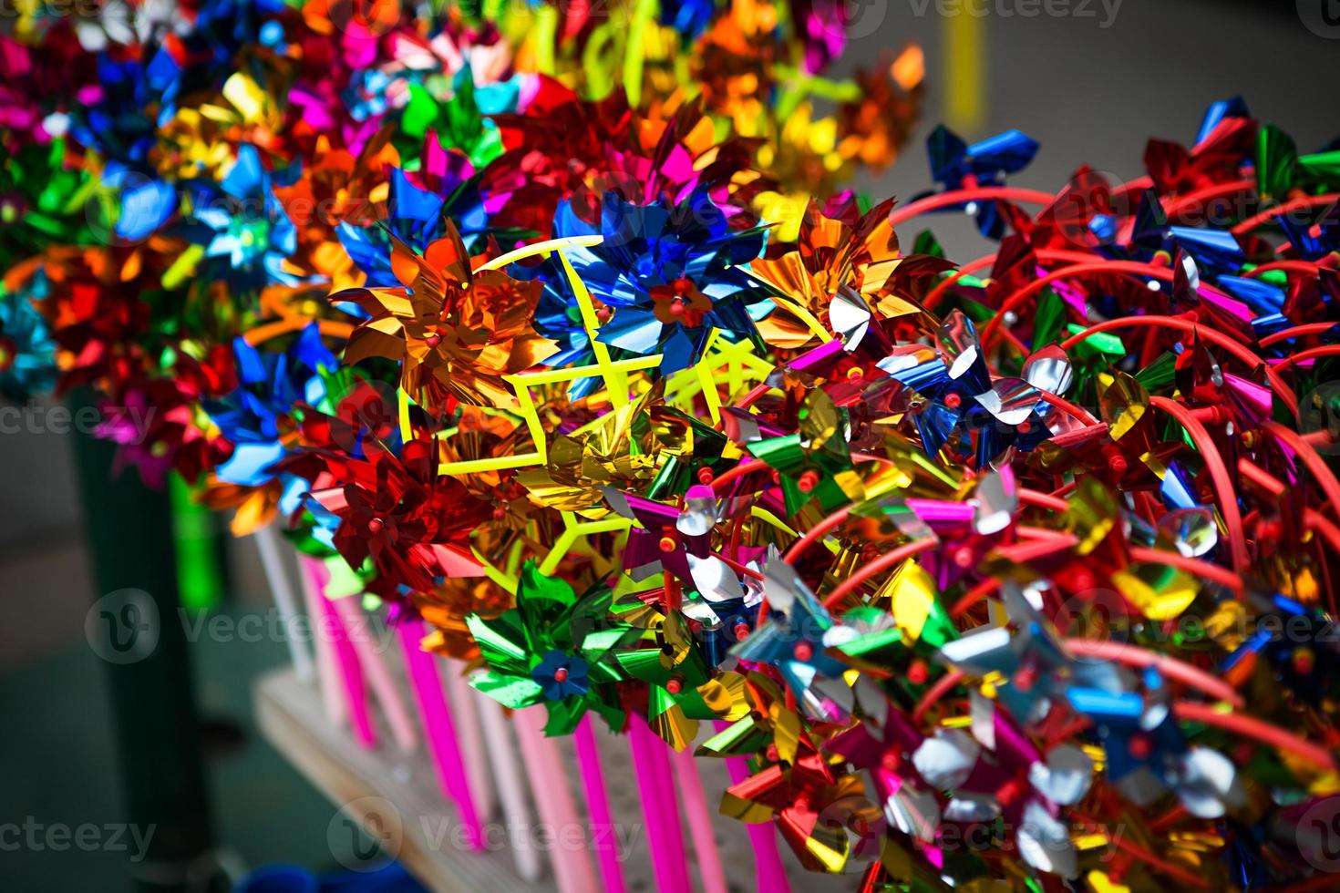 uma coleção de moinhos de vento de brinquedo colorido na vitrine. entretenimento para crianças foto