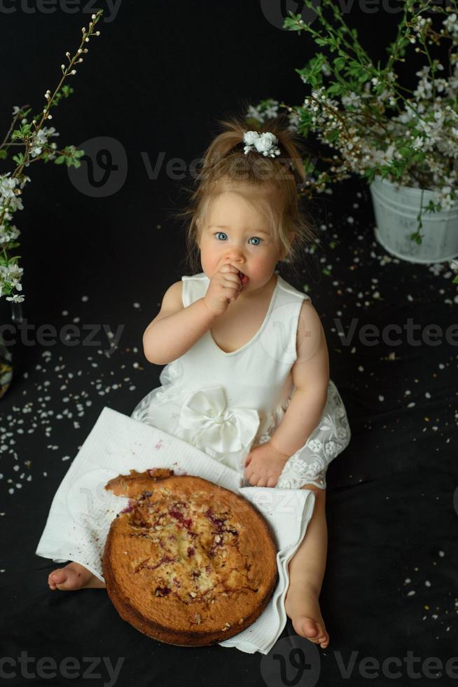 menina comemora seu primeiro aniversário. garota comendo seu primeiro bolo. foto