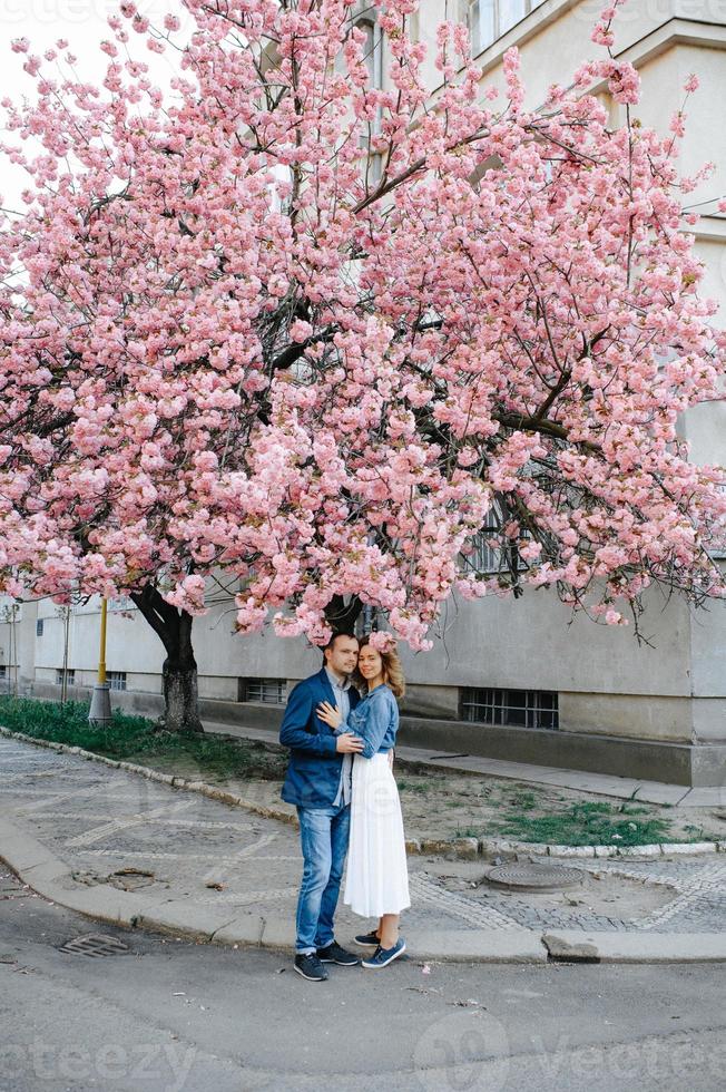 casal apaixonado em um pomar de macieiras florescendo deitado no cobertor foto