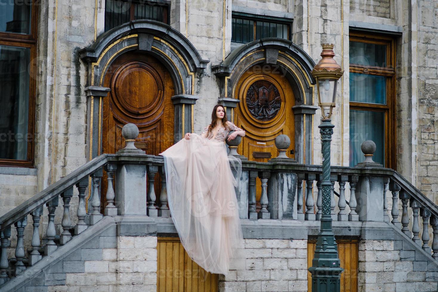 retrato de uma linda jovem em um vestido exuberante andando pelo parque e o grande palácio foto