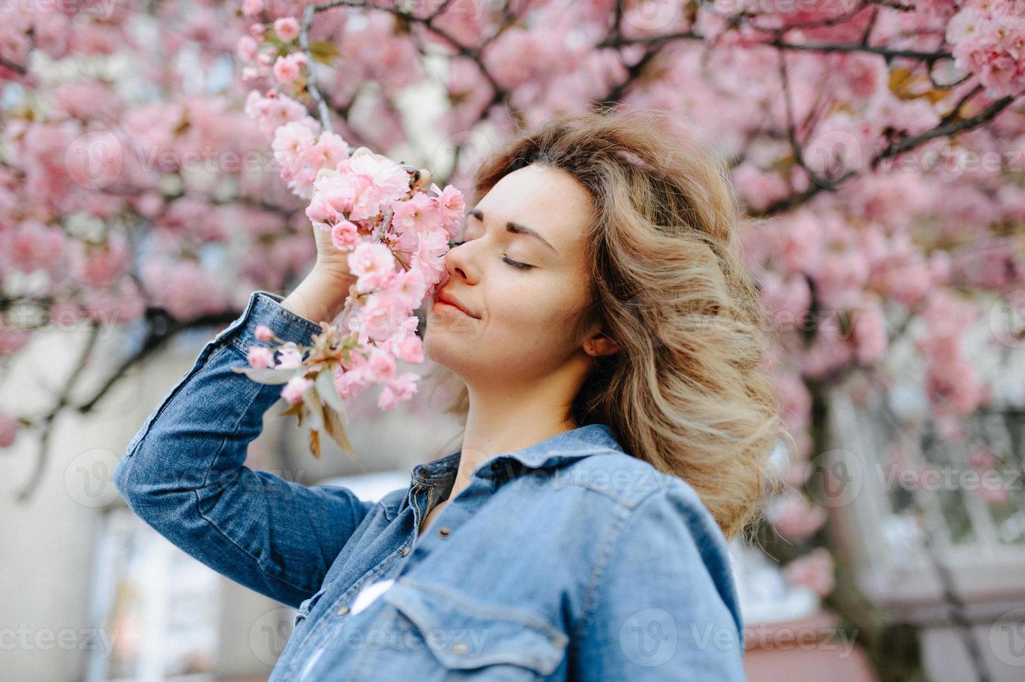 mulher bonita desfrutando de campo de margaridas, bela fêmea deitada no prado de flores, menina bonita relaxante ao ar livre, se divertindo, segurando a planta, jovem feliz e natureza verde primavera, conceito de harmonia foto