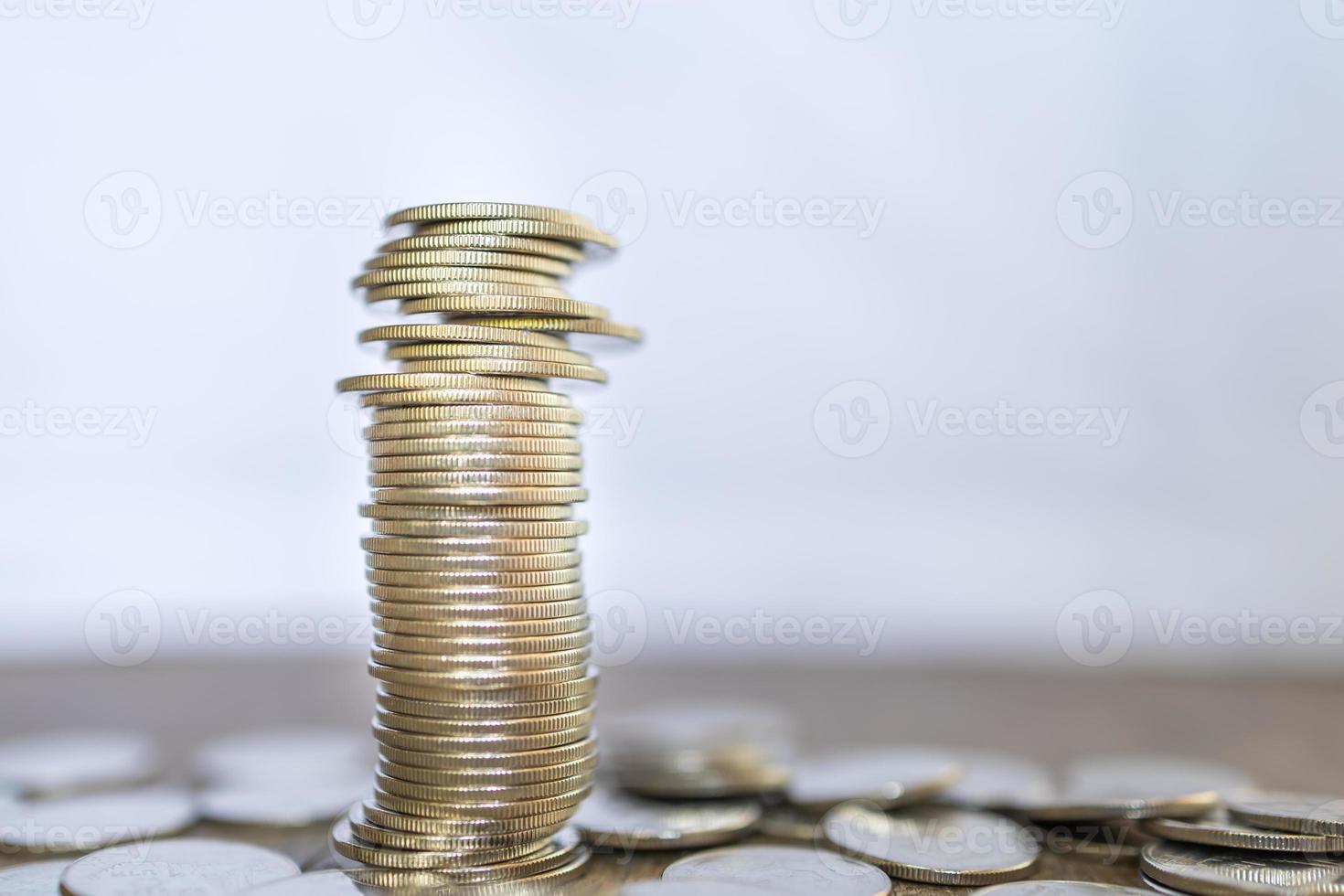 negócios, dinheiro, finanças, segurança e conceito de economia. feche a pilha instável de moedas na mesa de madeira com espaço de cópia. foto
