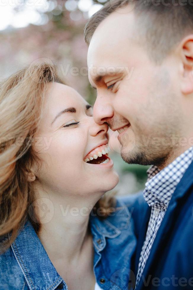 rostos de casal jovem amoroso rindo com os olhos fechados foto