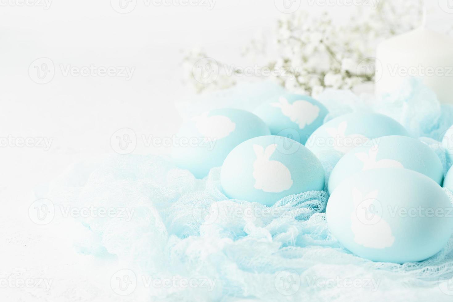 páscoa. feriado. fundo branco claro, cores pastel suaves. ovos azuis com imagem de coelho foto