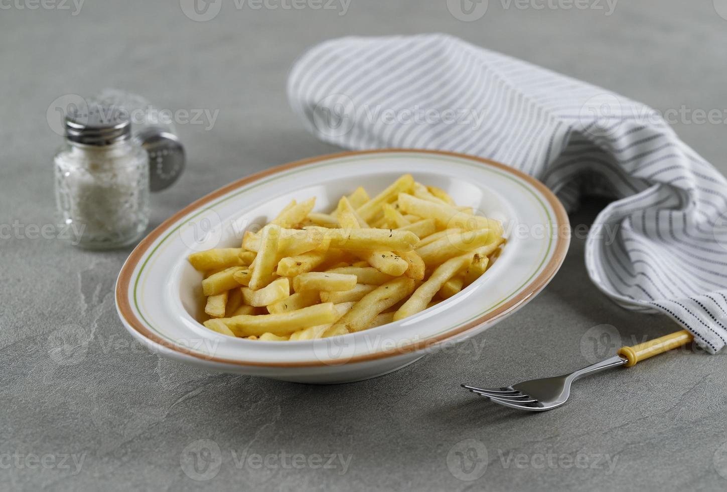 francês frito com sal e pimenta no fundo de cimento foto