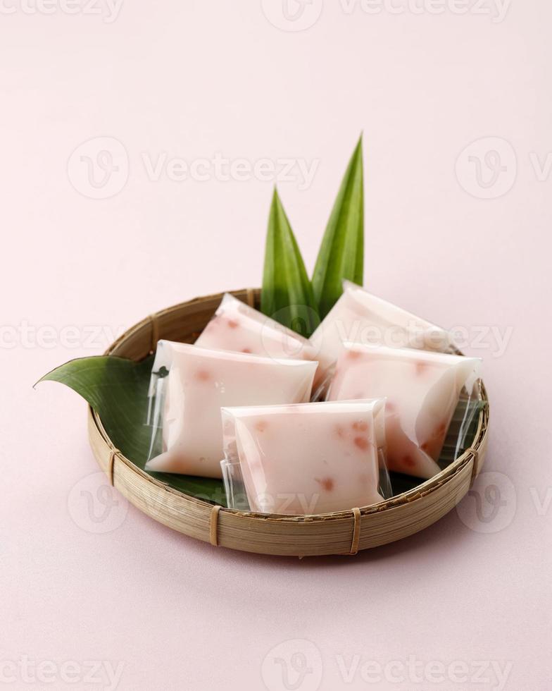 cantik manis kue pacar cina, cente é uma sobremesa tradicional indonésia feita com farinha de feijão mungo, pérola de sagu e leite de coco. servido na cesta de bambu foto