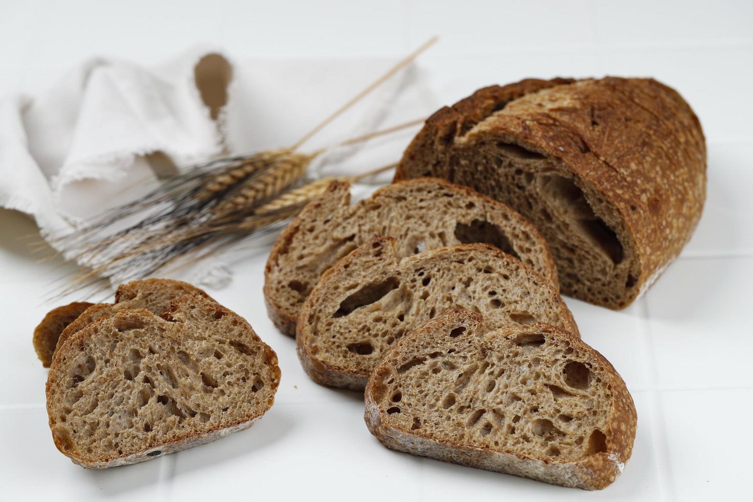 pão de fermento de espelta tradicional cortado em fatias em um fundo branco de madeira foto