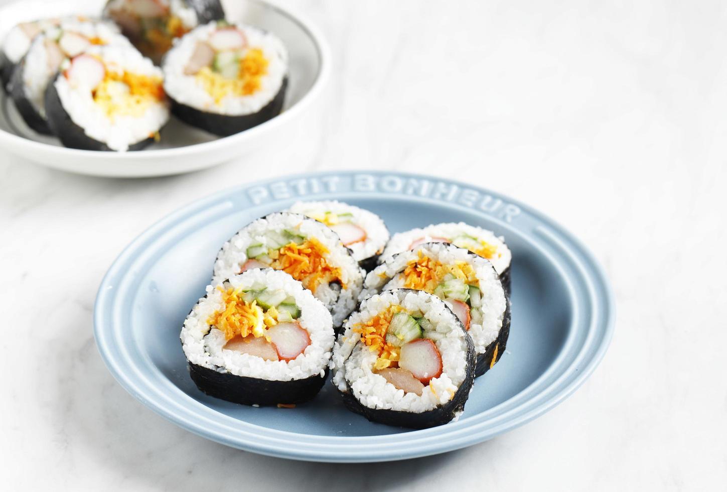 korean roll gimbap kimbob ou kimbap feito de bap de arroz branco cozido no vapor e vários outros ingredientes, como kyuri, cenoura, salsicha, vara de caranguejo ou kimchi e envolto com pia de algas marinhas foto