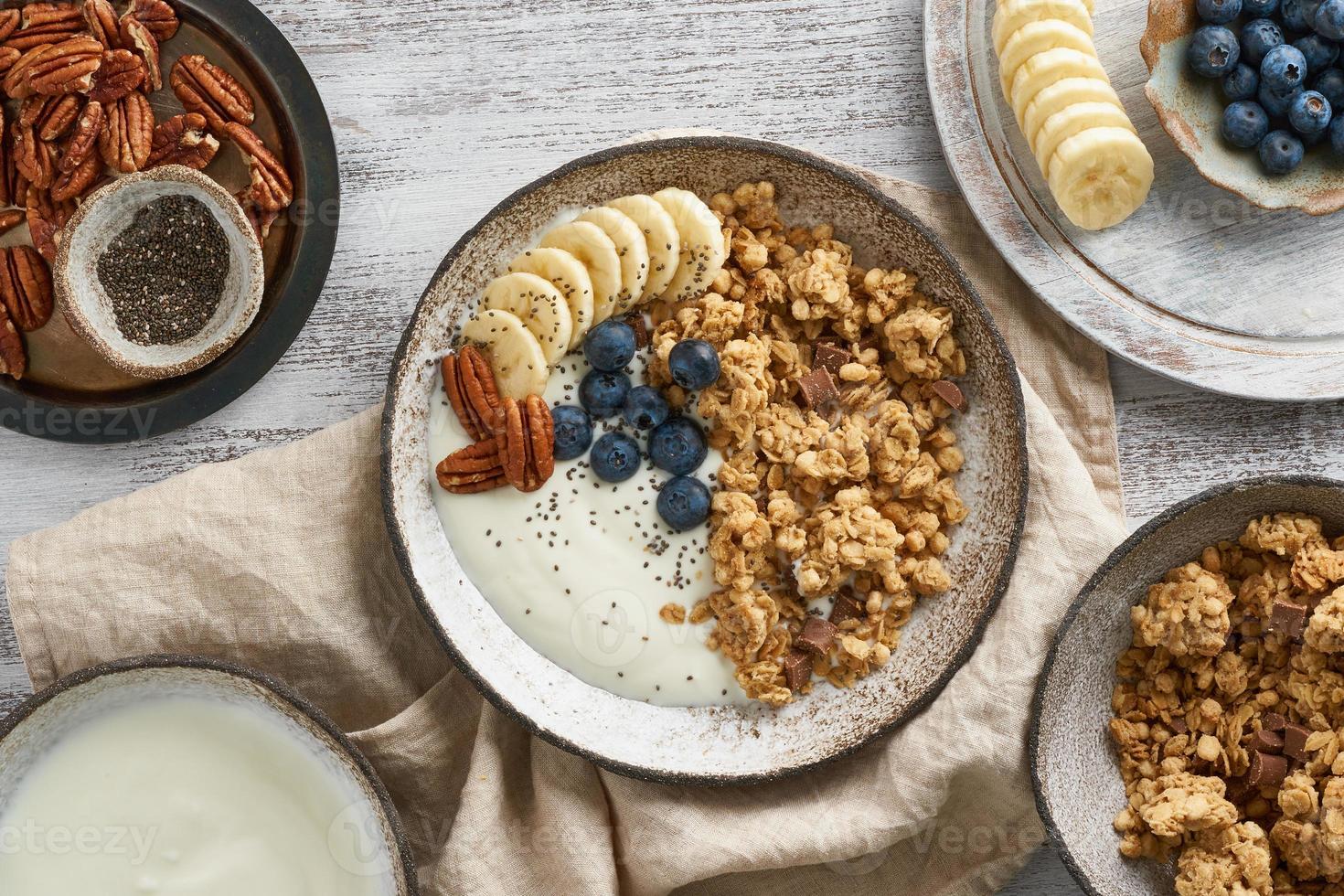 iogurte com granola de chocolate, mirtilo. café da manhã, comida de dieta saudável com flocos de aveia foto