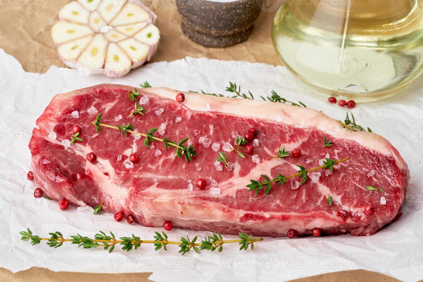 grande pedaço inteiro de carne de bovino crua, contrafilé em papel manteiga branco foto