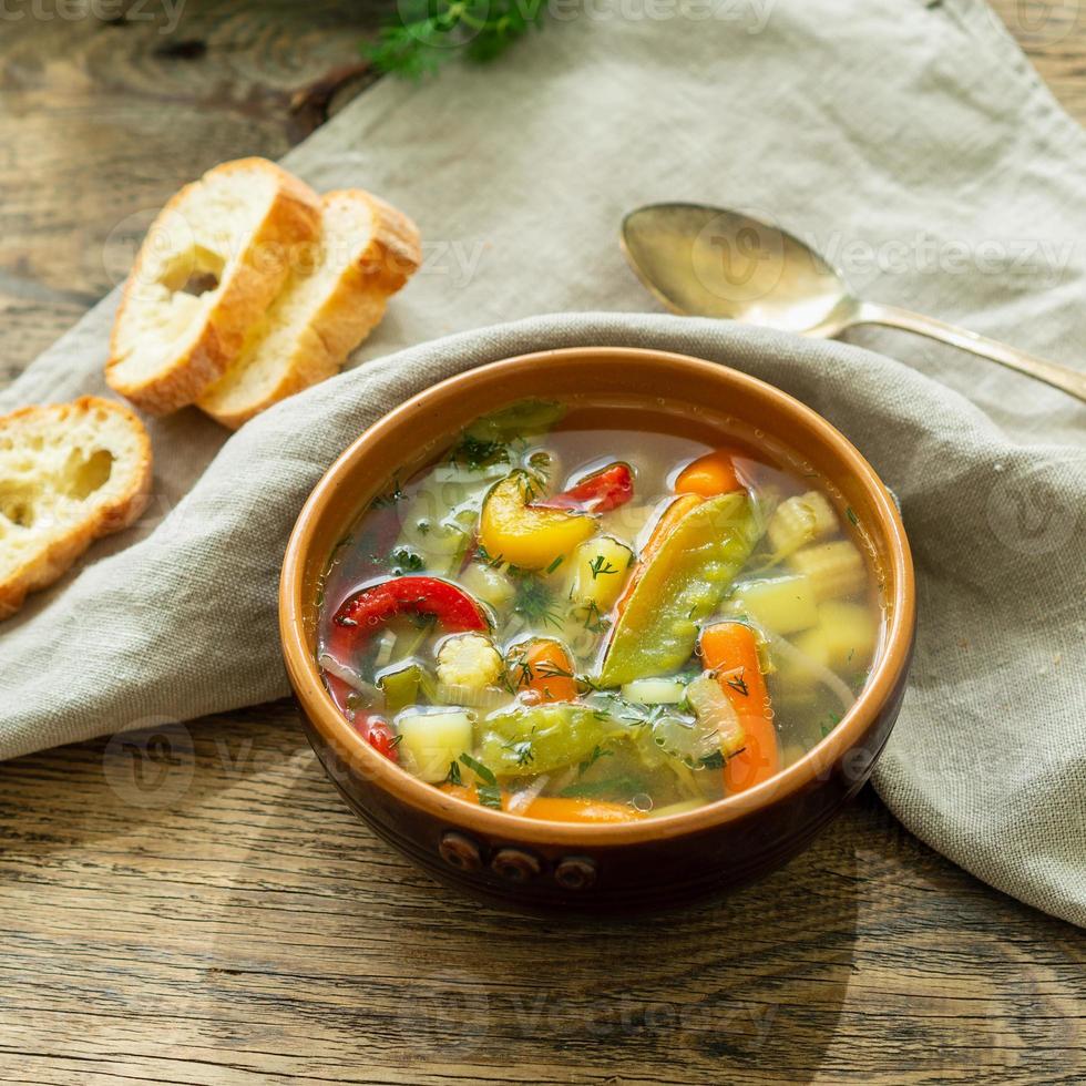 sopa vegetariana dietética vegetal de primavera brilhante. vista lateral, fundo de madeira rústica marrom, guardanapo de linho. foto