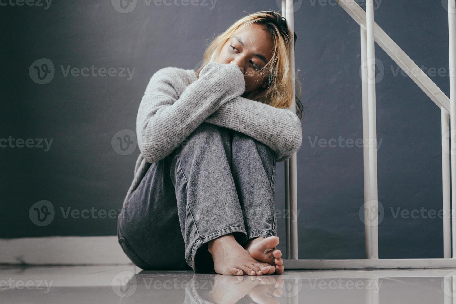 jovem deprimida e triste sentada sozinha em casa foto