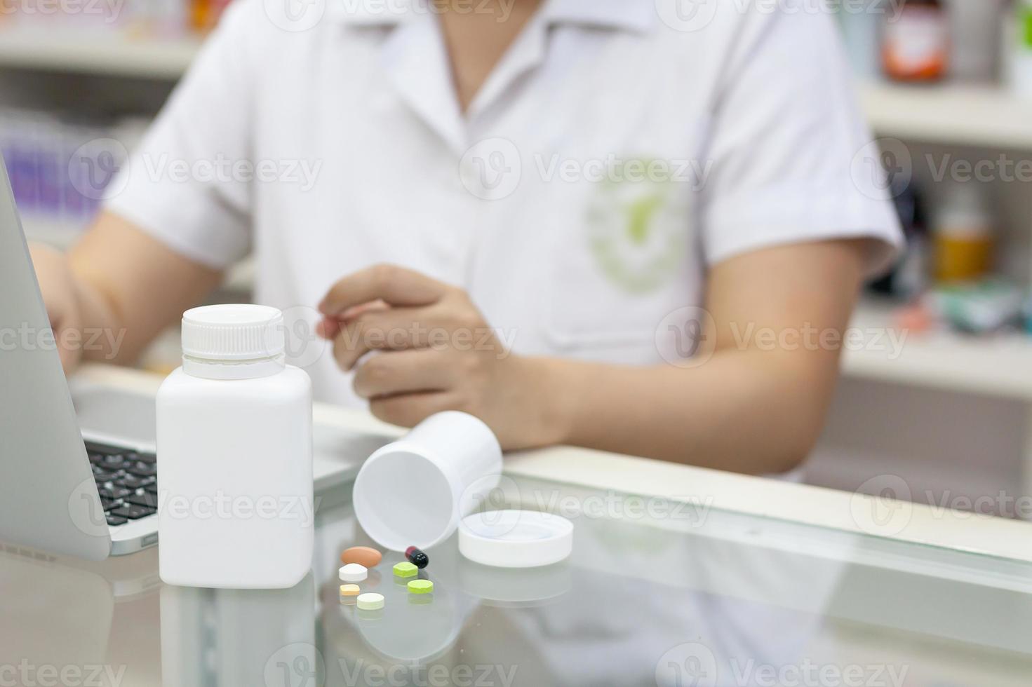 farmacêutico com computador portátil e medicação na farmácia foto