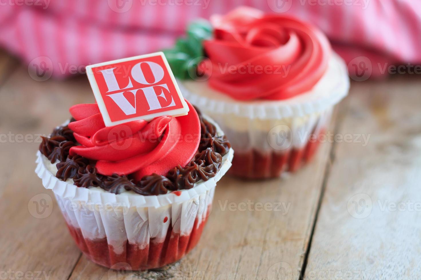 cupcakes de rosas vermelhas na mesa de madeira foto