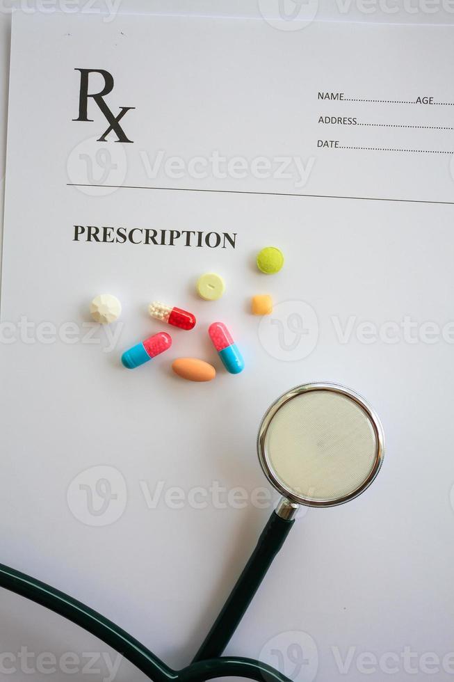 pílulas e estetoscópio com receita médica foto