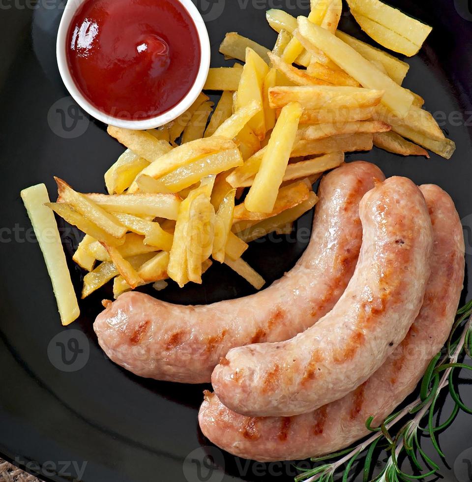 salsichas de frango grelhadas com acompanhamento de batatas fritas foto