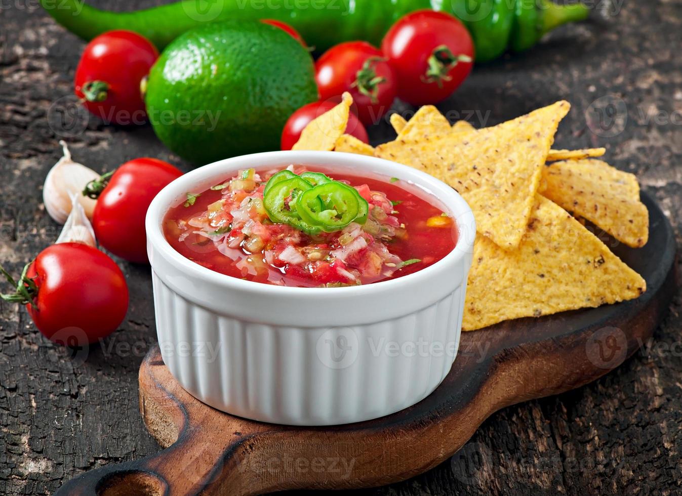 chips de nacho mexicano e molho de salsa na tigela sobre fundo de madeira foto