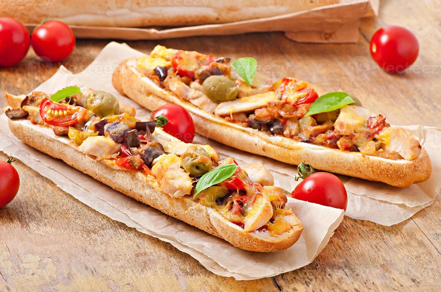 grande sanduíche com legumes assados e frango com queijo e manjericão em fundo de madeira velho foto