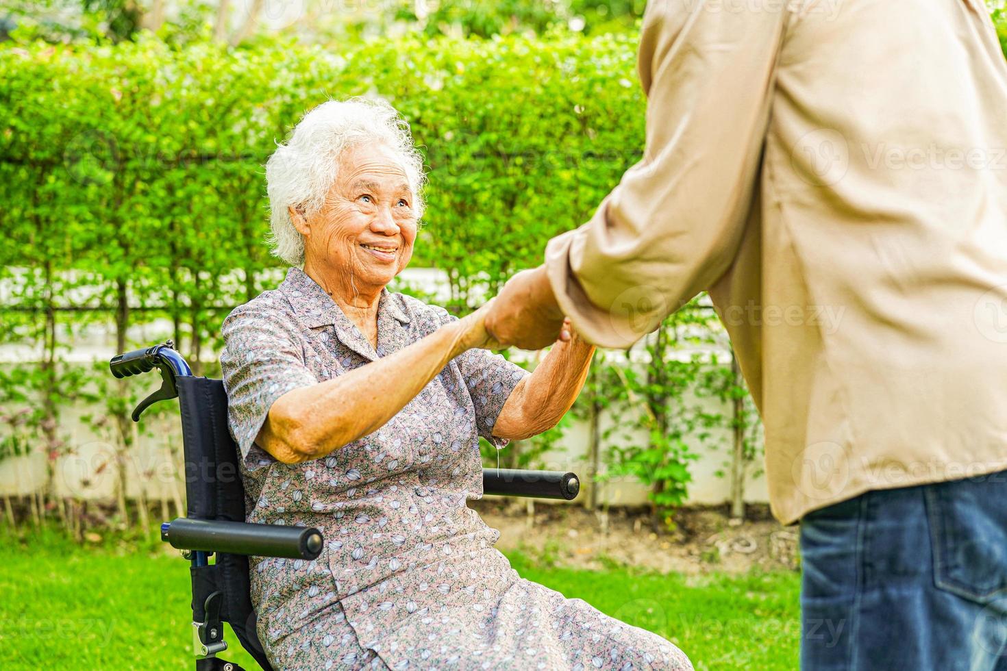 paciente com deficiência de mulher idosa asiática sentado na cadeira de rodas no parque, conceito médico. foto