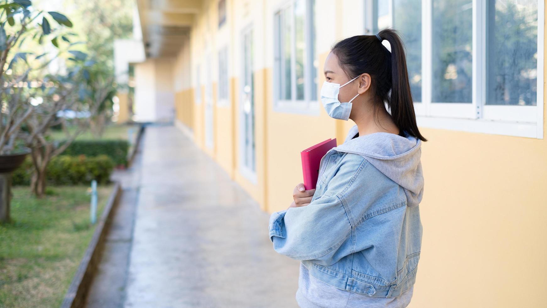 jovem estudante usa máscara andando na escola. foto