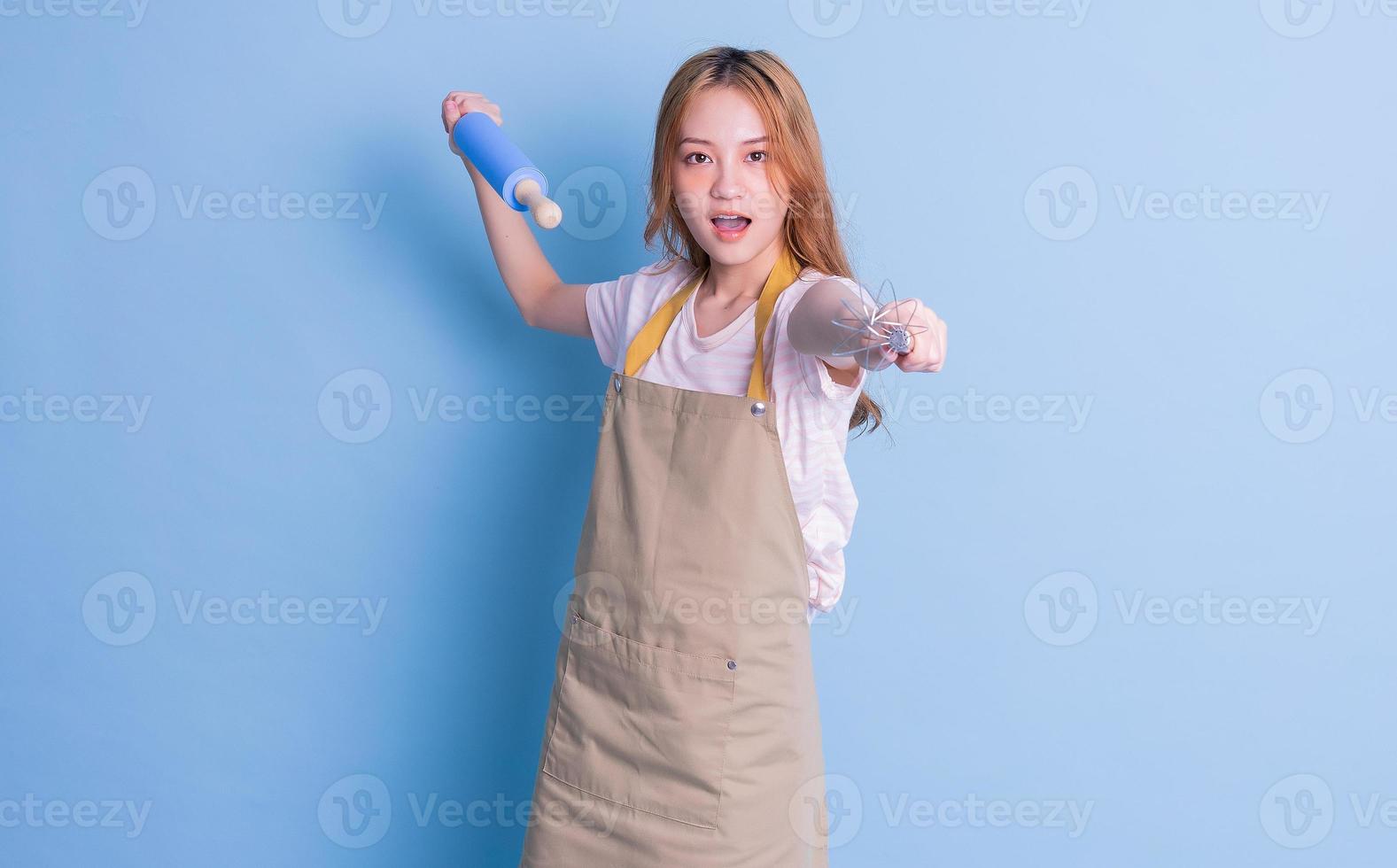 retrato de dona de casa posando em fundo azul foto